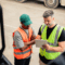 Two people talking while looking at a PrePass bypass mobile app on a tablet.