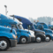 Why fleets bypassing weigh stations deliver more than freight. A row of trucks in a parking lot.