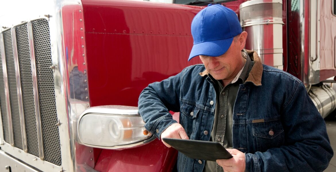 data visibility for tolls: man reading clipboard in front of truck
